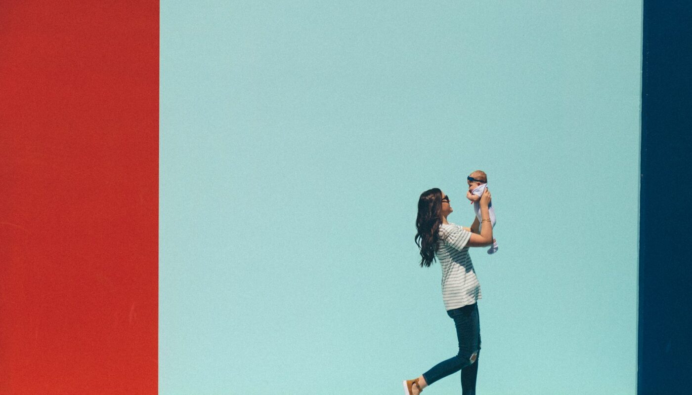 woman carrying baby while walking